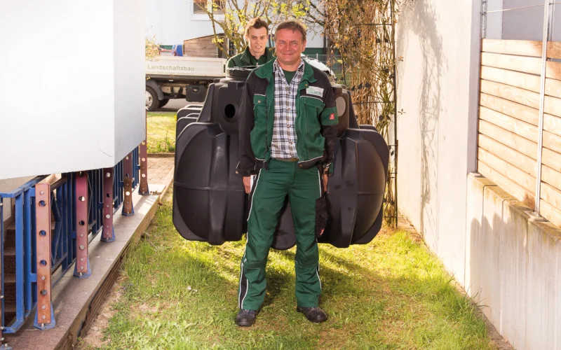 Handwerker tragen einen Wassertank von Graf