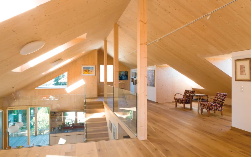 ausgebautes Dachgeschoss aus Holz mit Schrägdachfenstern und Sonneneinstrahlung