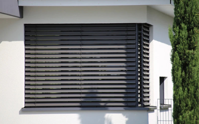 Sonnenschutz Alu-Rollläden vor einem Fenster