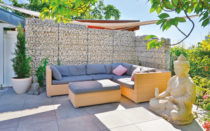 Sitzlounge an einer Gabione mit Steinen gefüllt als Sichtschutz