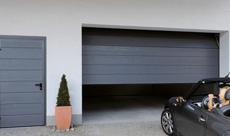 Dunkles Garagentor mit Nebentür in einer Garage