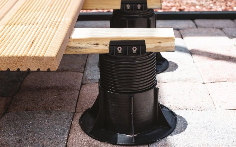 Ein einstellbareres Stelzlager, dass Terrassendielen aus Holz hält.