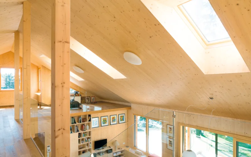 ausgebautes Dachgeschoss aus Holz mit Schrägdachfenstern und Sonneneinstrahlung