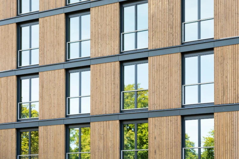 Fassade aus Holz und Glas eines großen Mehrfamilienhauses in Holzbauweise.