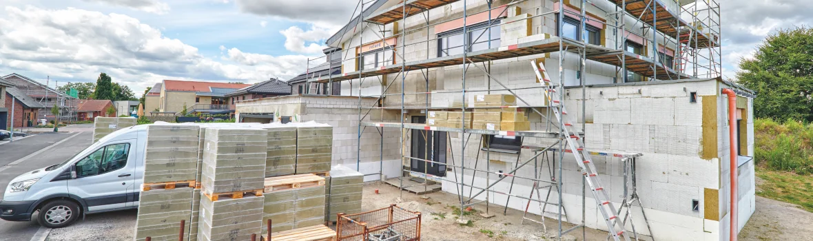 Hausbaustelle mit Gerüsten und Material