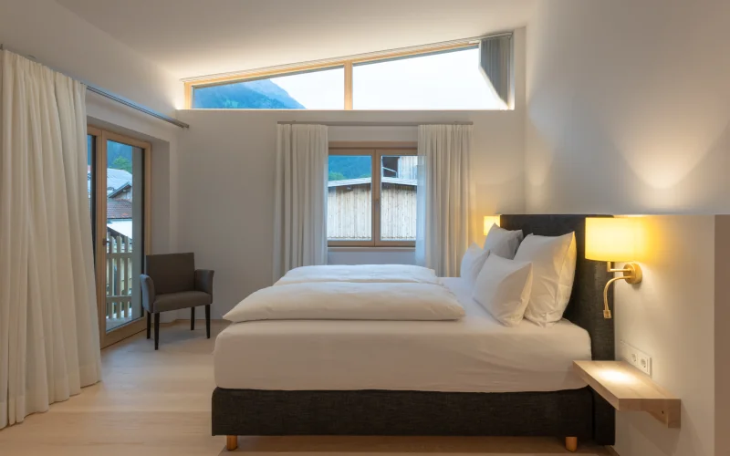 Schlafzimmer mit weißen Wänden und stimmungsvollem Licht