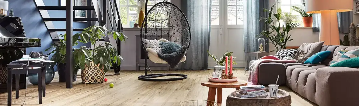 Loftartiger Wohnraum mit vielen Pflanzen, Holzfußboden und Sitzmöbeln 