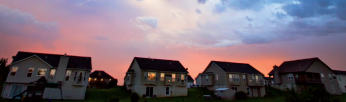Ein Sonnenuntergang hinter einer Siedlung aus Einfamilienhäusern
