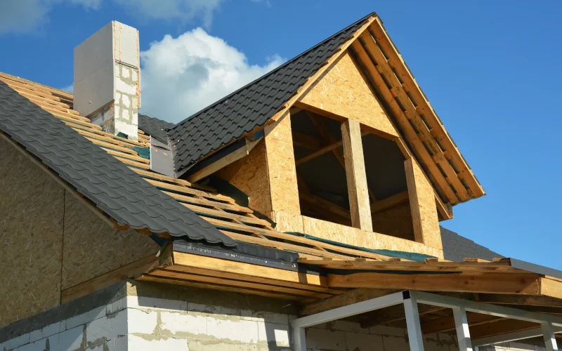 Hausdach im Bau mit OSB-Holz und teilweise gedeckten Ziegeln