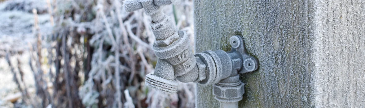 Ein Garten-Wasserhahn, der mit Frost bedeckt ist.