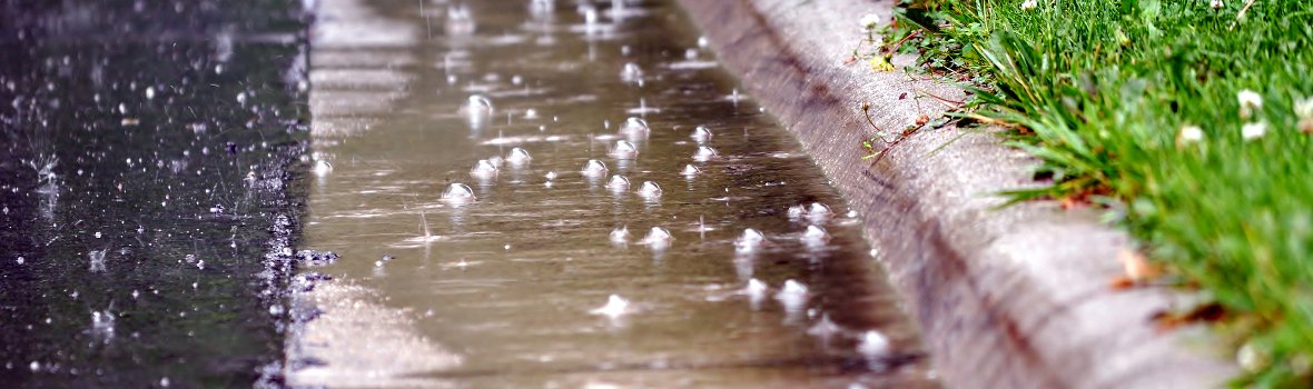Wasser läuft an der Seite der Straße zusammen