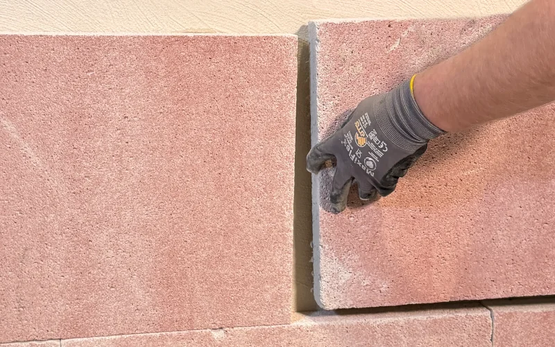 Handwerker bringt Mineraldämmplatten an der Fassade an