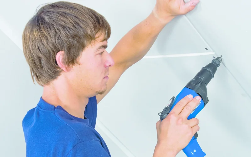 Handwerker bringt Gipsplatten an der Wand an