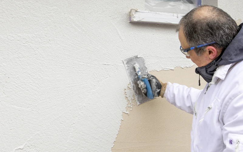 Handwerker verputzt Fassade, WARM-WAND Sprint Knauf