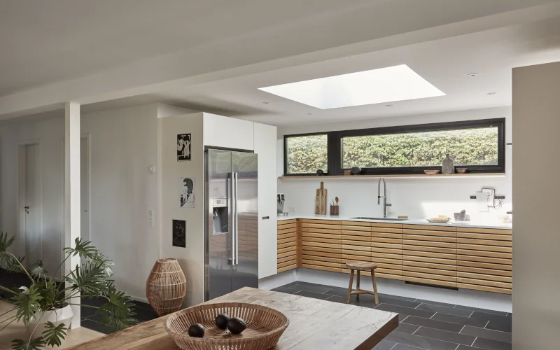 ein offener, heller Wohnraum mit Flachdach-Fenster in der Decke