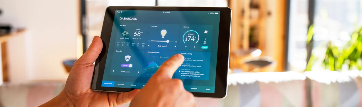 Mann hält Tablet in der Hand und steuert das Zuhause 
