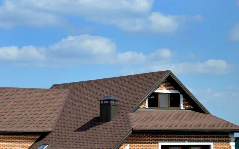 ein Haus mit braunem Walmdach und Klinkerfassade