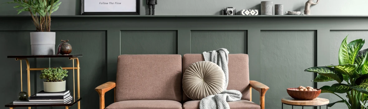 Sofa vor einer vertäfelten grünen Wand