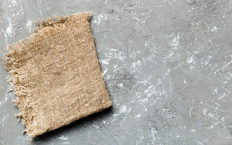 ein Untergrund aus Beton mit einem Stoff-Stück aus Hanf darauf liegend 