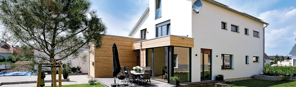 weißes Einfamilienhaus mit Garten und Terrasse