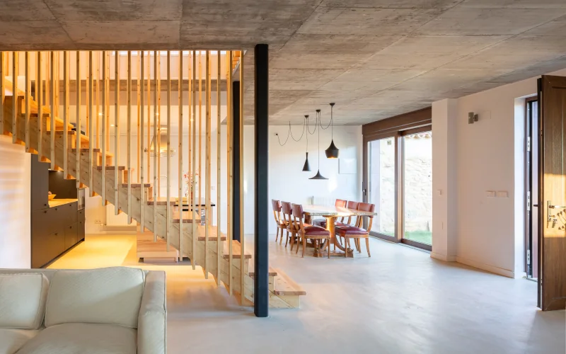 moderner Wohnraum mit Küche, Wohnzimmer und Esszimmer in einem mit Treppenaufgang