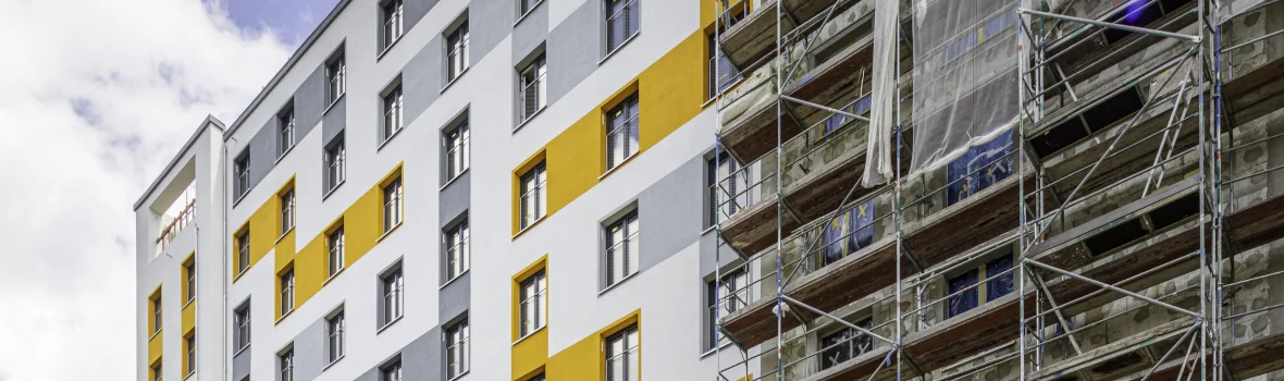 großer Wohnblock mit bunter Fassade mit Fassade in der Sanierung