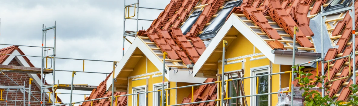 Haus im Bau mit Dachziegeln und Gerüsten.