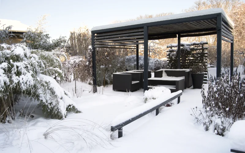 Pergola in einem Garten mit Schnee bedeckt
