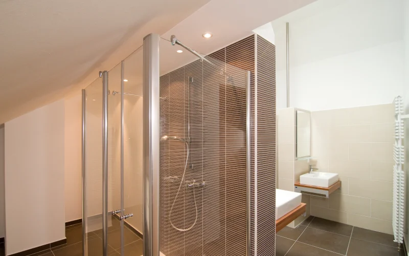 ein Badezimmer mit einer geräumigen Dusche und Dachschräge