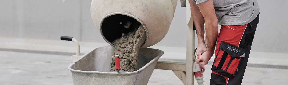 Mann bedient einen gefüllten Betonmischer der Beton mischt 