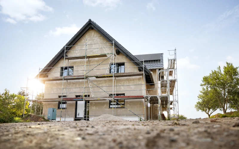 Haus mit Fassade in der Sanierung mit Gerüst davor 