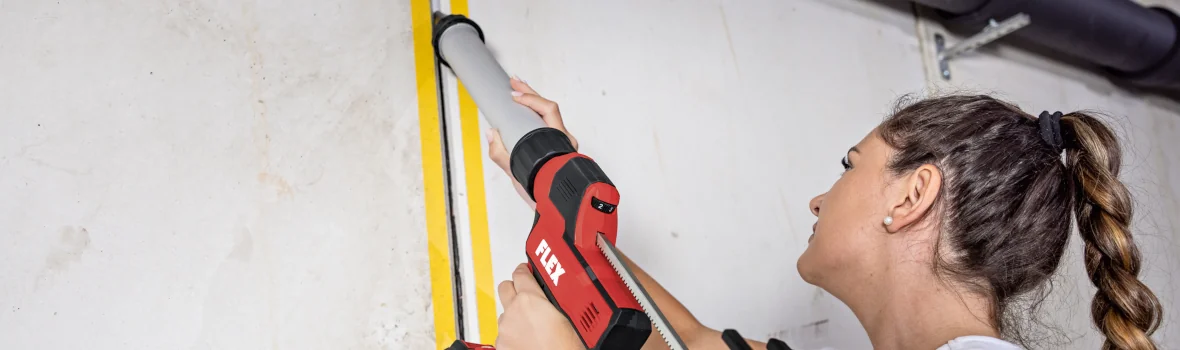 Handwerkerin benutzt zum Verfugen eine Akku-Kartuschenpresse von FLEX