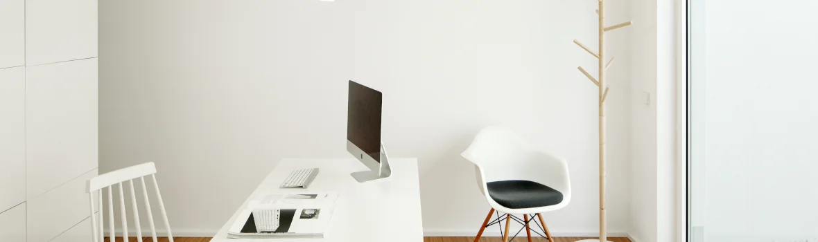 minimalistisches Arbeitszimmer mit weißen Wänden und Holzfußboden