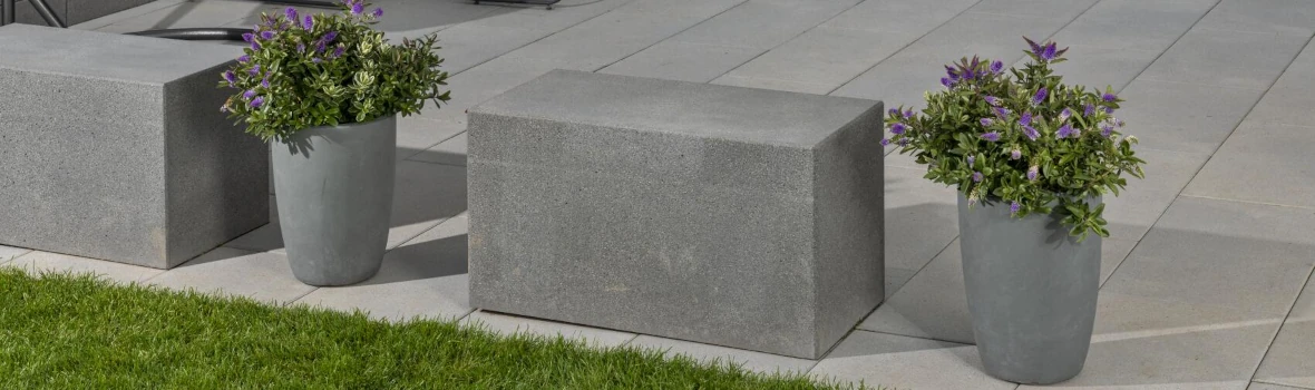 Terrasse mit Betonblöcken und Pflanzkübeln als Abtrennung