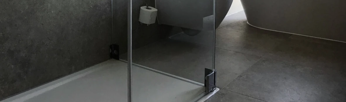 Badezimmerausschnitt mit anthrazitfarbenen Fliesen und ebenerdiger Dusche