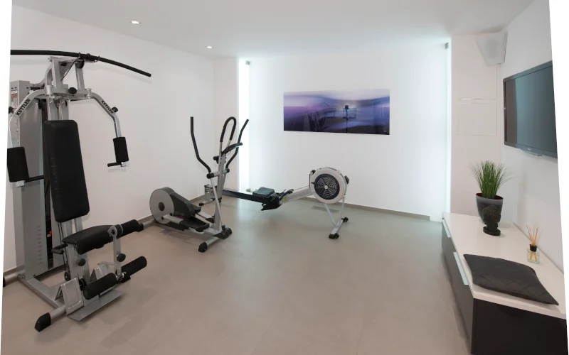 Heller Fitnessraum im Keller mit verschiedenen Sportgeräten