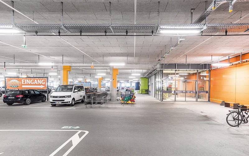 Tiefgarage mit vielen Autos und Einkaufsmöglichkeiten darin