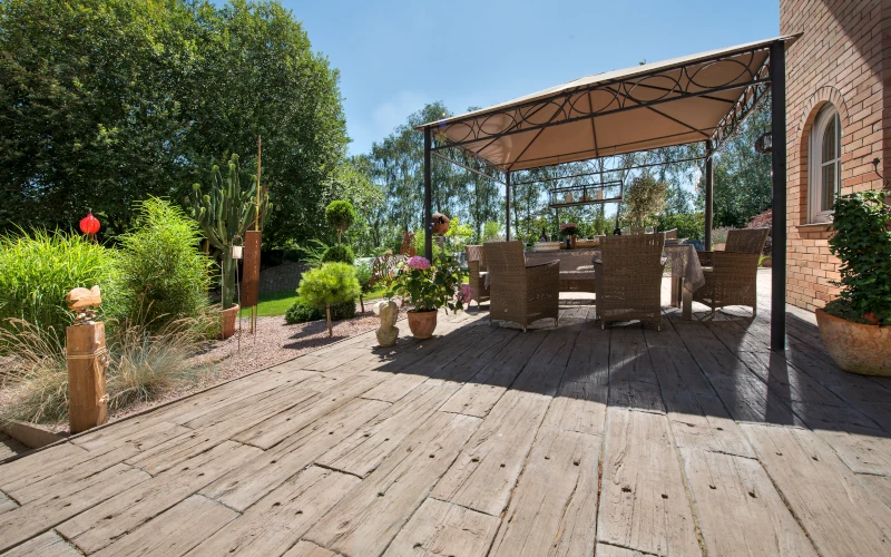 Terrasse mit Holzboden mit angrenzendem Garten 