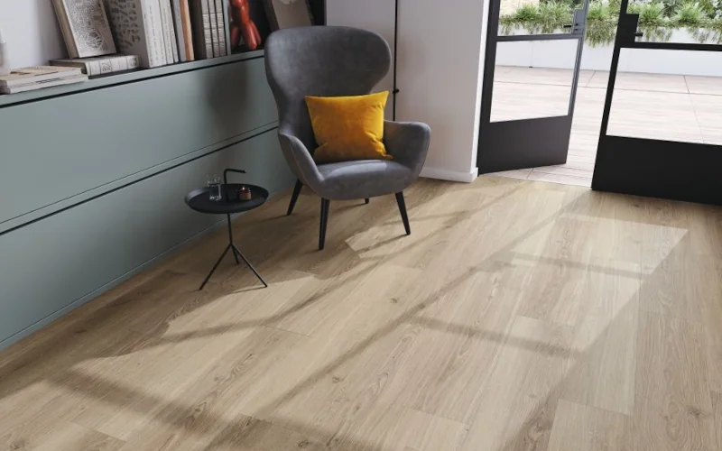 Wohnbereich mit Lesesessel und Kommode auf hellem Holzlaminat