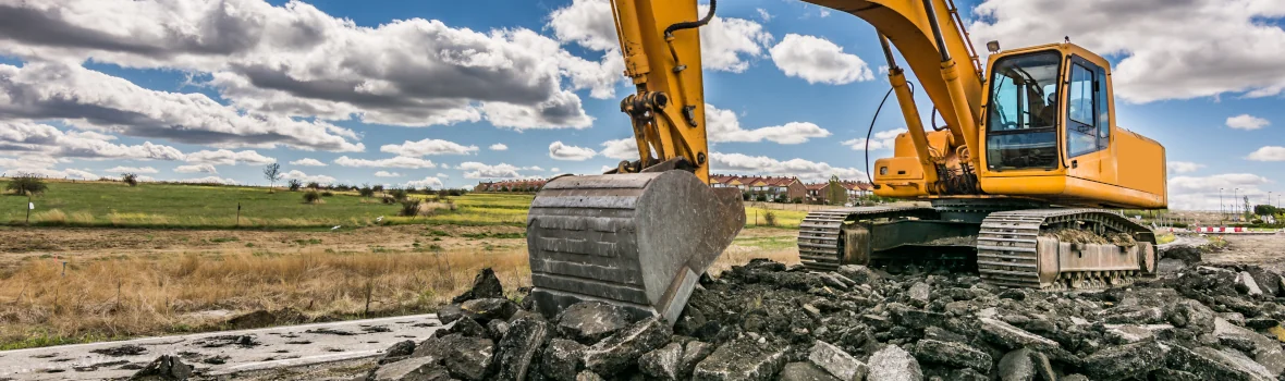 Bagger schaufelt Schutt mit der Schaufel 