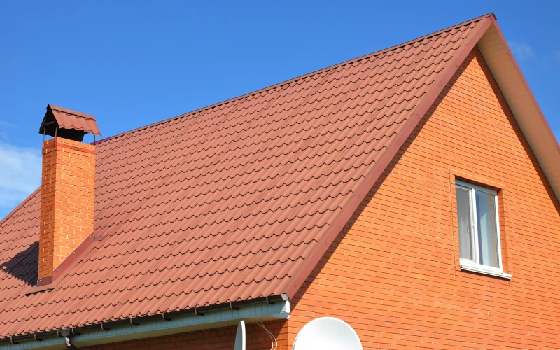 ein Haus mit rotem Satteldach und orangenen Klinkerfassade 