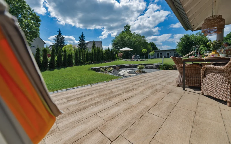 Terasse mit Platten in Holzoptik und Blick in den Garten