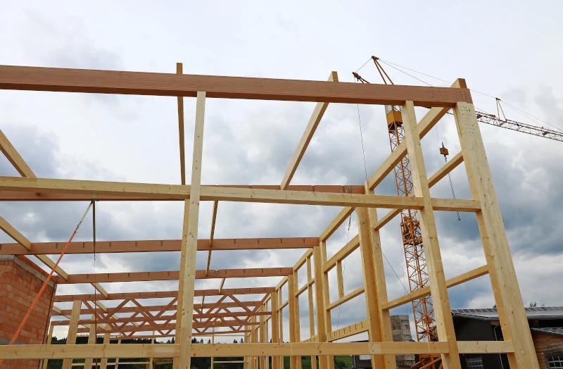 Holzbalken zusammengefügt zum statischen Grundgerüst für einen größeren Gewerbebau.