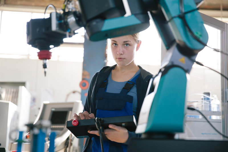 Frau programmiert an einem Roboter