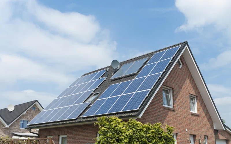 Solarpaneele auf einem Hausdach mit blauem Himmel im Hintergrund