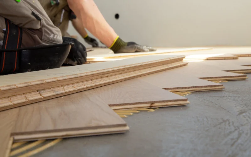 Handwerker verlegt Laminat auf dem Boden 