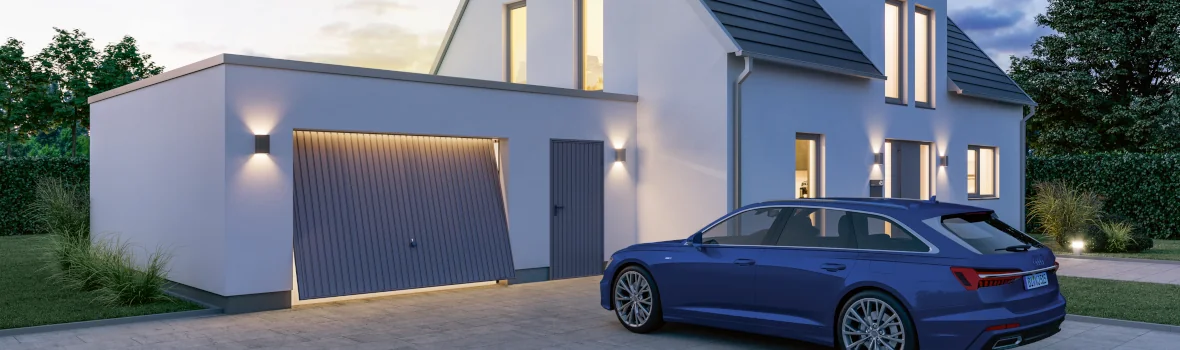 Einfamilienhaus mit Garage, Auto und Beleuchtung in der Abenddämmerung