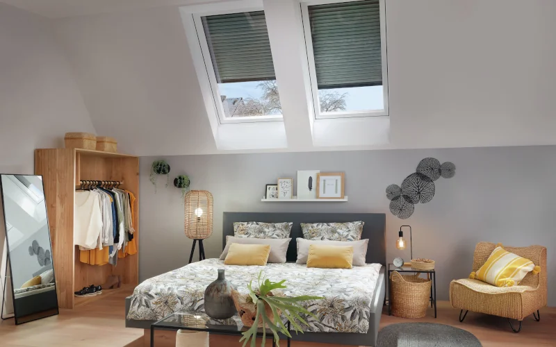 Schlafzimmer mit Bett in der Mitte und Dachfenstern