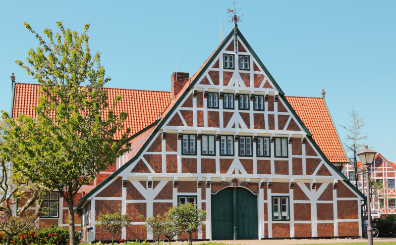Fachwerkhaus mit großem Ziergiebel, traditioneller Bauweise und Ziegeldach.
