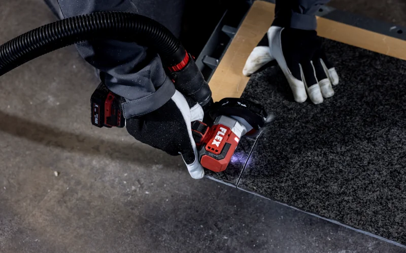Flex Mini-Winkelschleifer schneidet ein Stück Fliese 